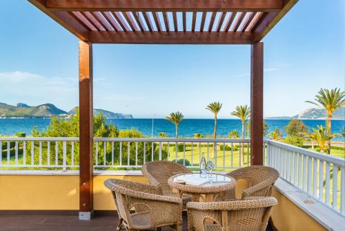 a table and chairs on a balcony with a view of the ocean at Club del Sol Aparthotel in Port de Pollensa