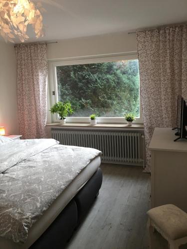 Un dormitorio con una cama y una ventana grande. en Apartement Merlin, en Wilhelmshaven