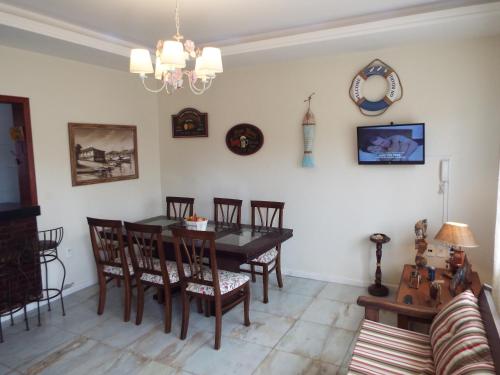 a dining room with a table and chairs at Casa 3 dormitórios sendo uma suíte com ar - condomínio de 6 casas - piscina do condomínio - Pagamento de sinal para reservar in Torres