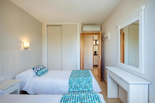 a hotel room with two beds and a mirror at Apartamentos Los Manueles in San Agustin