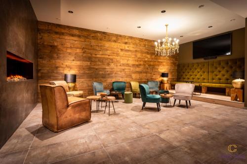 a lobby with chairs and tables and a tv at Chalets Coburg in Schladming