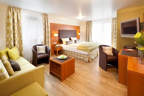 een hotelkamer met een bed en een bank bij Altstadt-Hotel Zum Hechten in Füssen
