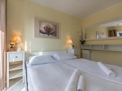 a bedroom with a large white bed with two pillows at VacationClub - Rezydencja Bursztyn Apartament 31 in Świnoujście