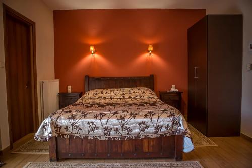 a bedroom with a bed and orange walls at Andromeda Hotel Limni Plastira in Koutsodímos