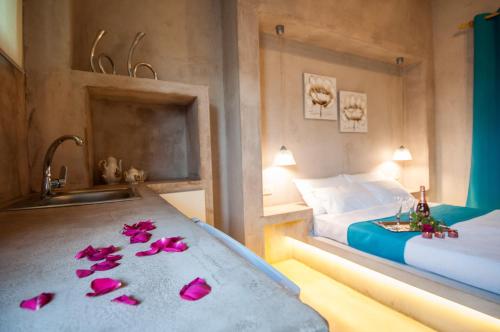 a bedroom with a bed and a sink and pink flowers on the floor at Zante Nest Studios & Apartments in Alikanas