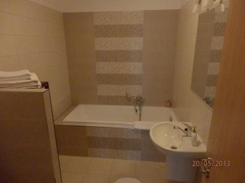 a bathroom with a bath tub and a sink at Penzion Linhart in Poděbrady