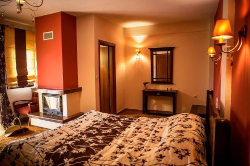 a bedroom with a bed and a fireplace at Andromeda Hotel Limni Plastira in Koutsodímos