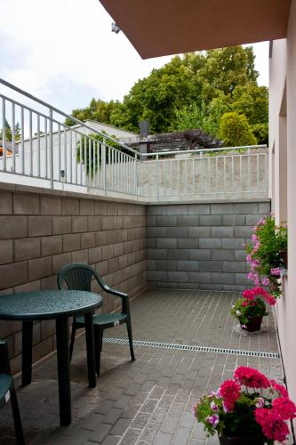 a patio with a table and chairs and flowers at Penzion Linhart in Poděbrady
