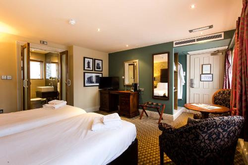 una camera d'albergo con due letti e una sedia di Maltsters a Cardiff
