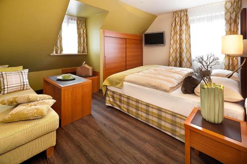 a hotel room with two beds and a couch at Altstadt-Hotel Zum Hechten in Füssen