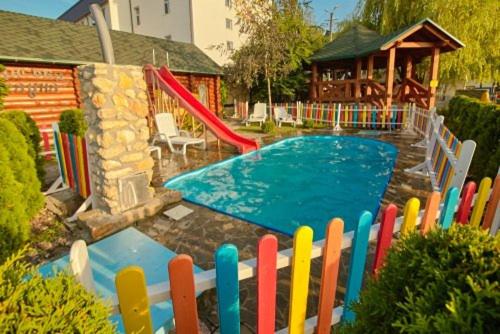 a colorful fence in front of a pool with a slide at Hotel Panorama in Kremenetsʼ