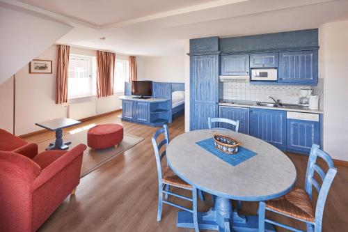 a living room with a table and a kitchen at INSELHUS Apartments in Baltrum