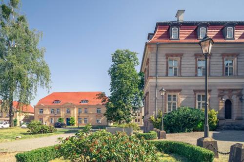 an old building with a red roof on a street at Hotel Schloss Neustadt-Glewe in Neustadt-Glewe