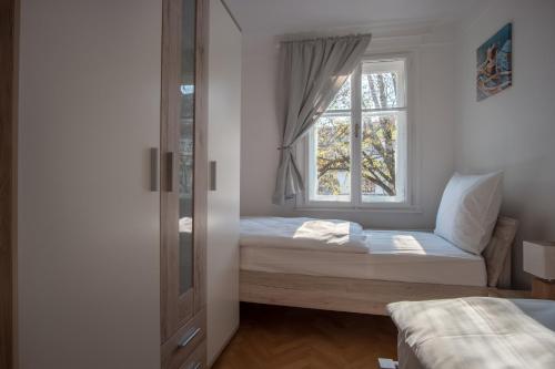 a small bedroom with a bed and a window at River View Apartment in Ljubljana