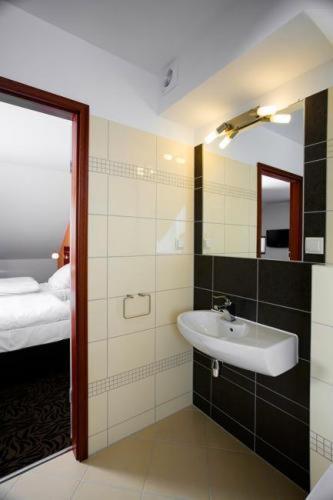 a bathroom with a sink and a bed at Hotel Azyl in Kąty Wrocławskie