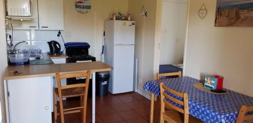 a small kitchen with a table and a refrigerator at 123 hbc in Hermanus