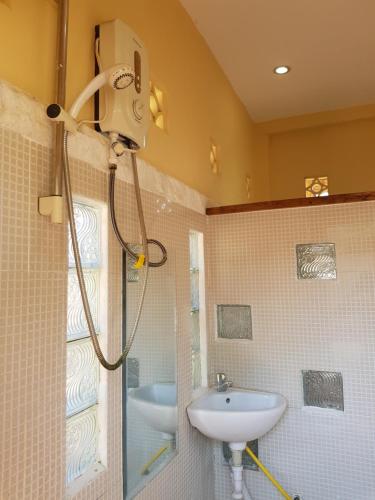 uma casa de banho com um chuveiro e um lavatório. em Sofinny Motel 2 em Sihanoukville