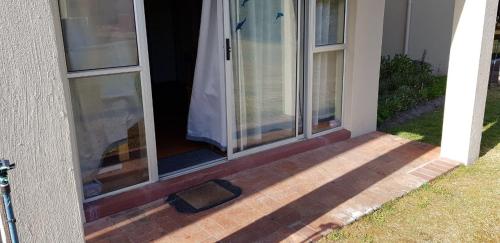 an open door of a house with a cat on the porch at 123 hbc in Hermanus