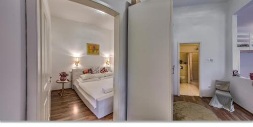 um quarto com uma cama branca e um espelho em Julia's Home em Budapeste