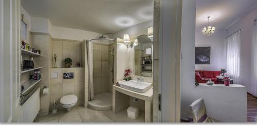 uma casa de banho com um chuveiro, um WC e um lavatório. em Julia's Home em Budapeste