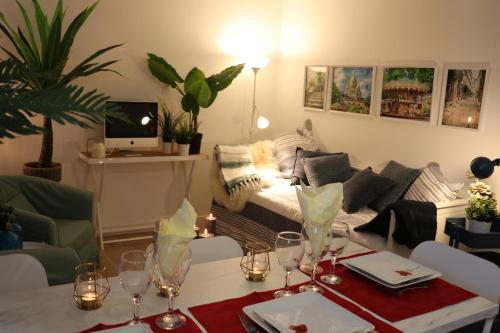 a living room with a couch and a table with wine glasses at Léa de Paris in Noisy-le-Grand