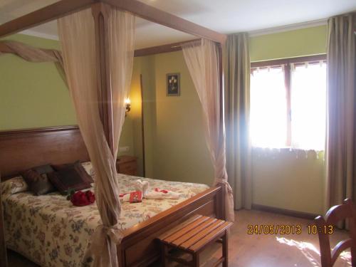 a bedroom with a canopy bed and a window at Hotel Marfrei in Hinojedo