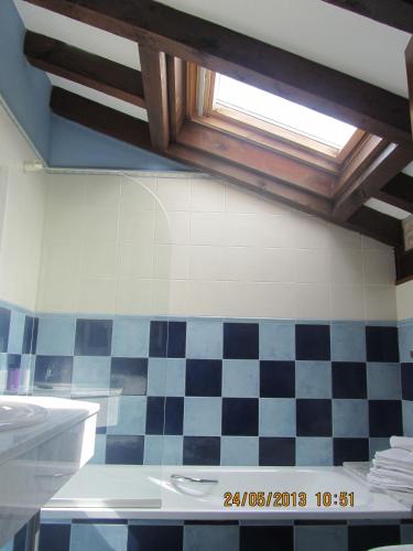 a bathroom with a sink and a checkered wall at Hotel Marfrei in Hinojedo