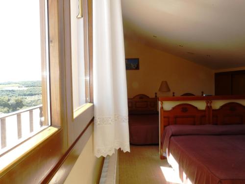 a bedroom with a bed and a window at Hostal Rural Casa Castro in Alberuela de la Liena