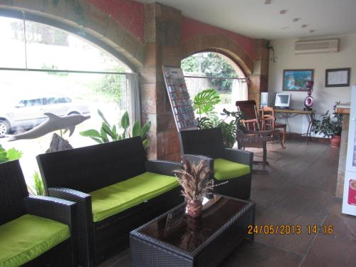 a living room with couches and a table and chairs at Hotel Marfrei in Hinojedo