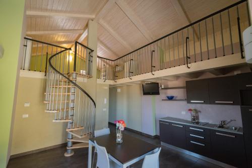 a kitchen with a spiral staircase and a table at Eco-Residence in Casale Monferrato