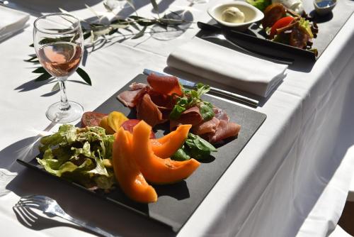 a table with a plate of food and a glass of wine at Résidence Les Calanques in Ajaccio