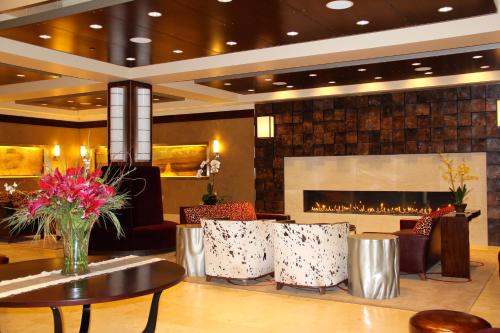 a lobby with a fireplace and a table and chairs at Northern Hotel in Billings