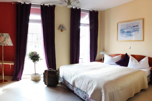 a bedroom with a bed and a large window at Berliner Hof in Dallgow