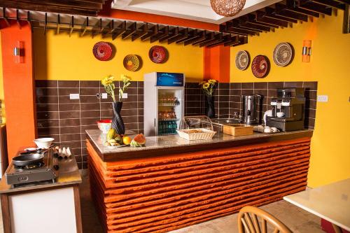 a kitchen with orange and yellow walls and a counter at Njema Court Apartment in Nairobi