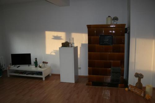 uma sala de estar com um frigorífico e uma televisão em Ferienwohnung Wettin em Wettin