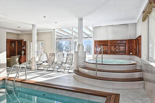 a room with a pool and chairs and a table at Hotel Gassenwirt in Chienes