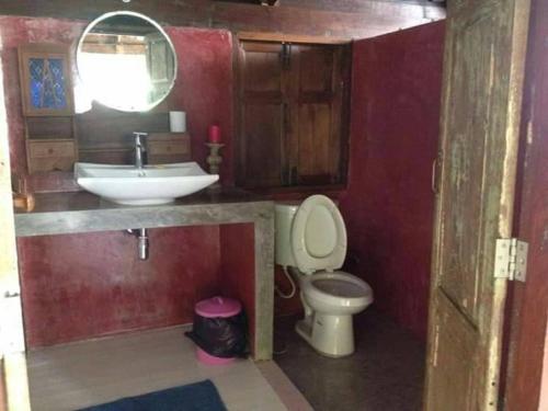 a bathroom with a sink and a toilet and a mirror at Khaokor Remind by Palek in Khao Kho