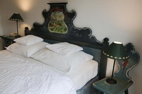 a bedroom with a bed with a headboard and a lamp at Hotel Sonnenhof - bed & breakfast & appartements in Innsbruck