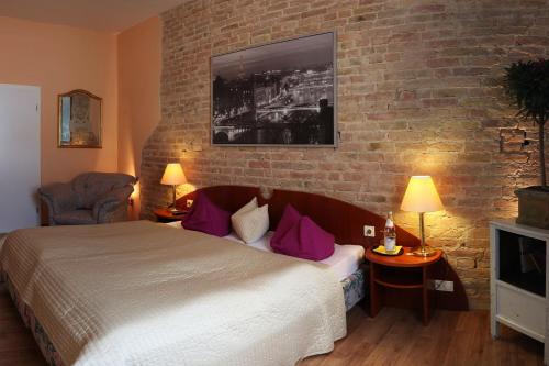 a bedroom with a bed and a brick wall at Berliner Hof in Dallgow