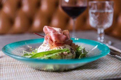 a plate of food on a table with meat and vegetables at Palladio Hotel Buenos Aires - MGallery Collection in Buenos Aires