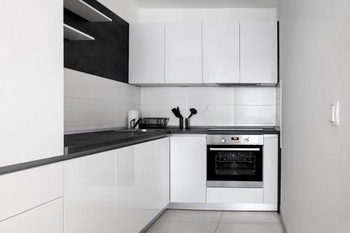 a white kitchen with white cabinets and an oven at Sauna - Flexible SelfCheckIns 6 - Zagreb - Garage - Electric vehicle ccharger - Loggia - New - Luxury - Apartments Repinc 6 in Zagreb