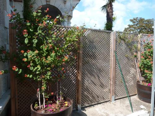a fence with potted plants and flowers on it at Chambres d'Hôtes L'Insulaire in Saint-Denis-dʼOléron
