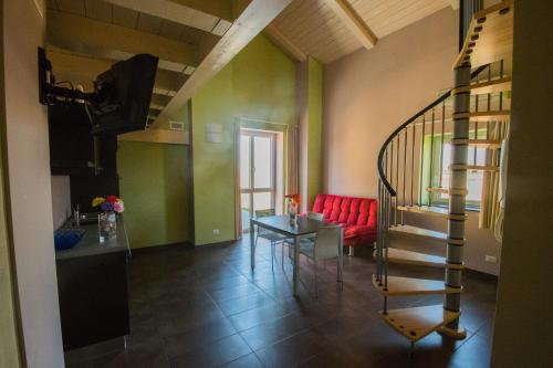 a living room with a spiral staircase and a red couch at Eco-Residence in Casale Monferrato