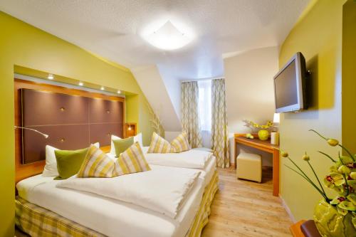 a hotel room with a bed and a television at Altstadt-Hotel Zum Hechten in Füssen