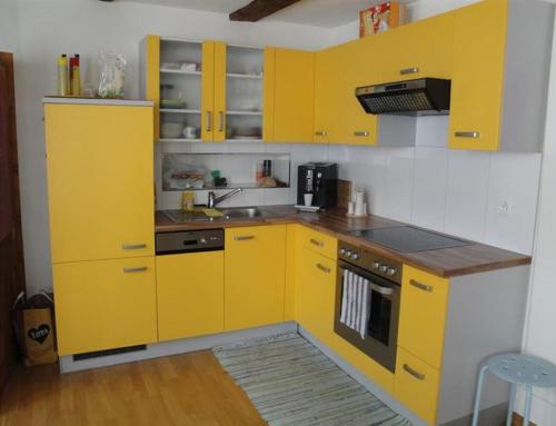 eine gelbe Küche mit einer Spüle und einem Herd in der Unterkunft Altstadtappartment in Altstätten