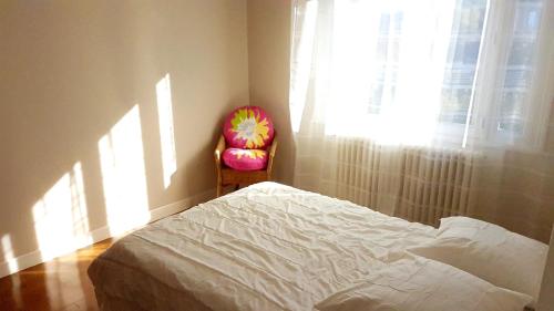 a bedroom with a bed and a chair and a window at maison spacieuse renovée in Longeville-en-Barrois