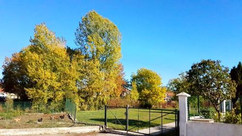 a gate in front of a field with trees at maison spacieuse renovée in Longeville-en-Barrois