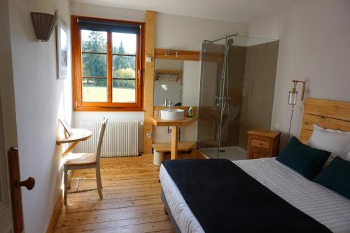 sypialnia z łóżkiem oraz łazienka z umywalką w obiekcie Auberge de la Perdrix w mieście Hauterive-la-Fresse