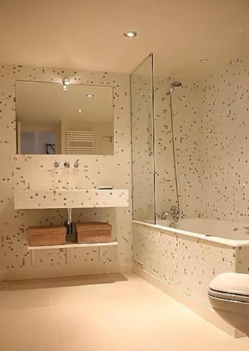 une salle de bain avec douche, toilettes et miroir dans l'établissement Charming Cosy Triplex in Trendy Marais, à Paris