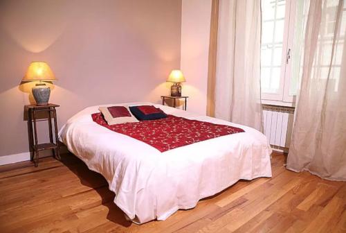 a bedroom with a large bed with a red blanket at Charming Cosy Triplex in Trendy Marais in Paris